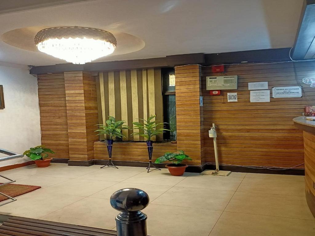 a lobby with potted plants in a building at Hotel Maxx in Lucknow