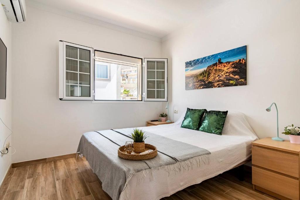 een slaapkamer met een groot bed in een kamer met ramen bij Villa Aspen Gran Canaria in Arguineguín