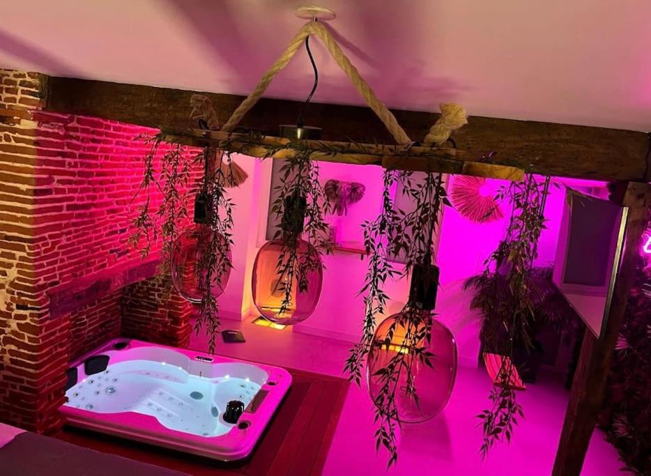 LéguevinにあるLove Room Toulouseのバスタブとピンクの照明のあるピンクの部屋