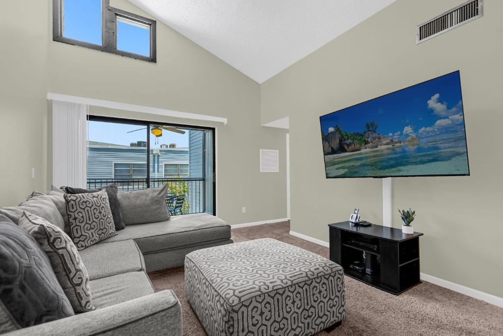 una sala de estar con un sofá y una mesa en Modern Cozy 2BR Condo Near Disney, en Orlando