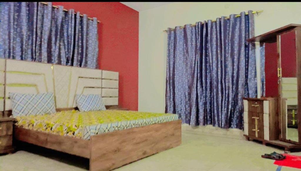 1 dormitorio con 1 cama y cortinas azules en Blue diamond guest house en Karachi