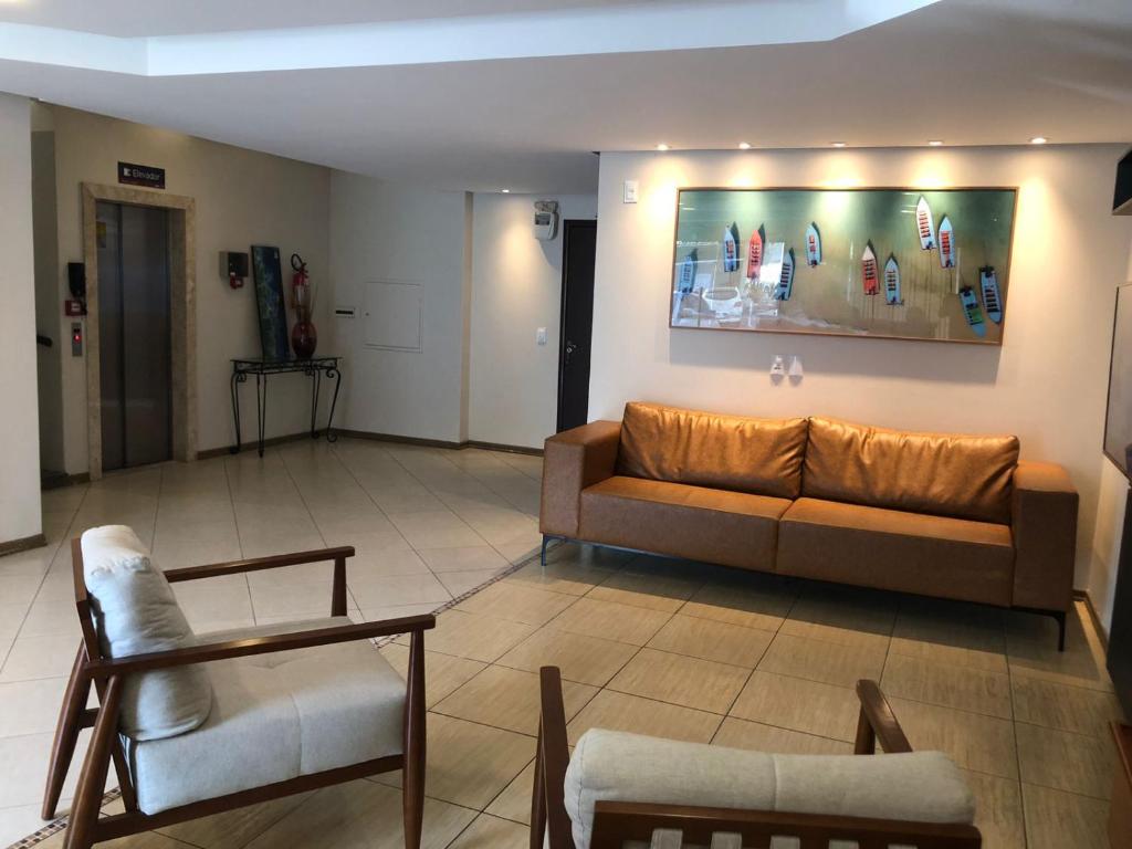 a living room with a couch and chairs in it at Hotel Graju Itajaí in Itajaí