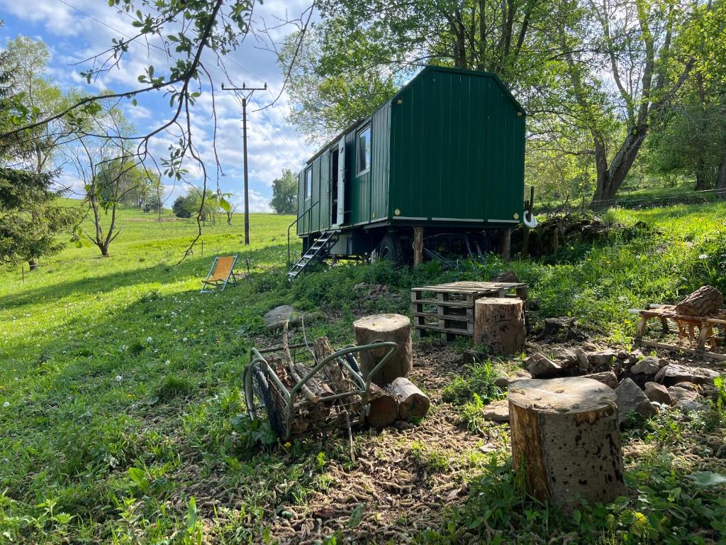 a green train car sitting in a field at MECHový domeček pod Bobíkem in Volary