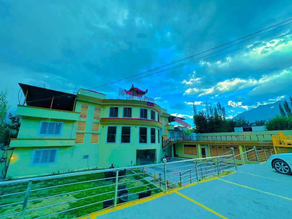 een gebouw met een hek voor een parkeerplaats bij POLO LAND HOTEL Skardu in Tandal