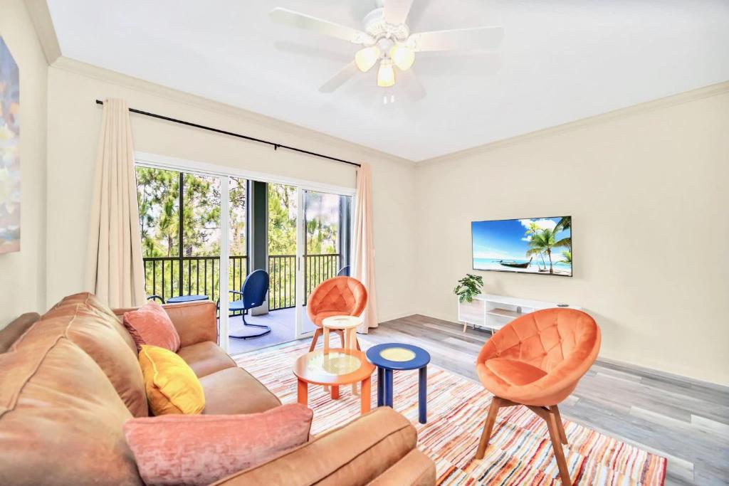 ein Wohnzimmer mit einem Sofa und Stühlen in der Unterkunft 3BR Condo with Hot Tub and Pool - Near Disney in Orlando