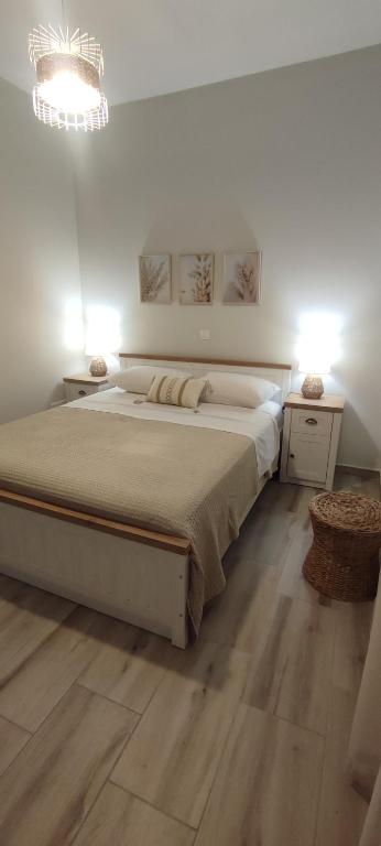 a white bedroom with a large bed and two night stands at Casa di Calma in Ermoupoli