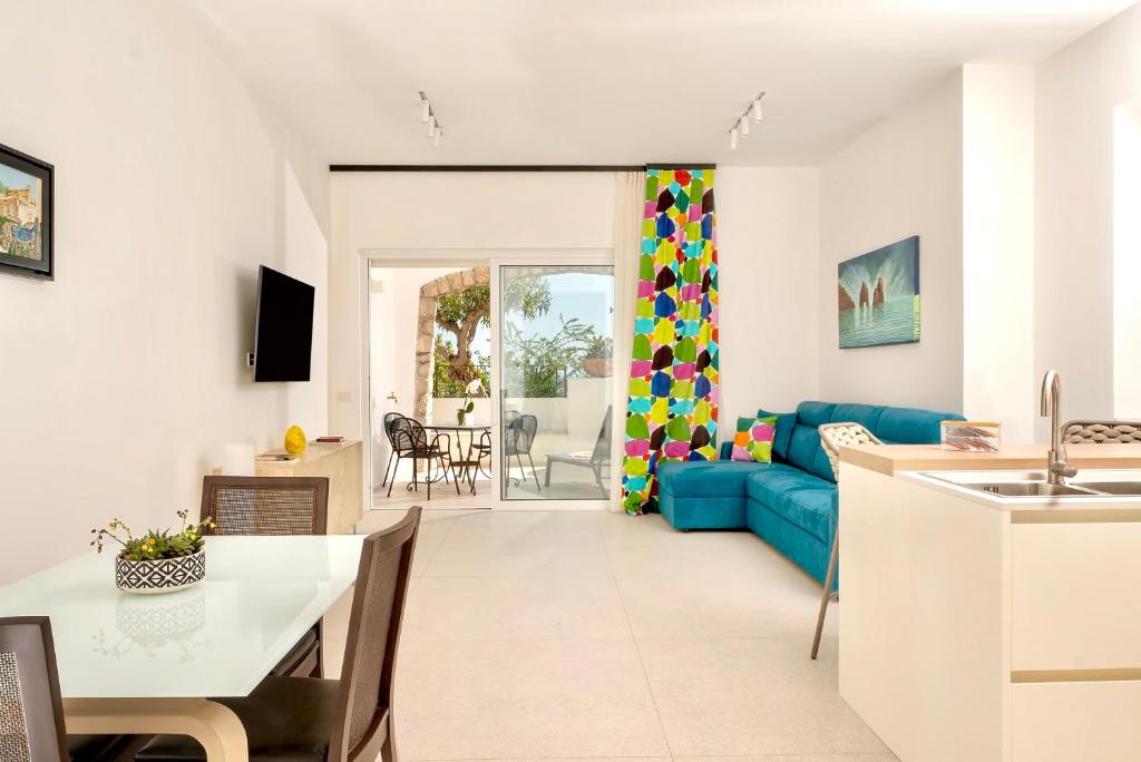 Il comprend une cuisine et un salon doté d'un canapé bleu. dans l'établissement Le donne di Capri - Charming apartments in Capri, à Capri