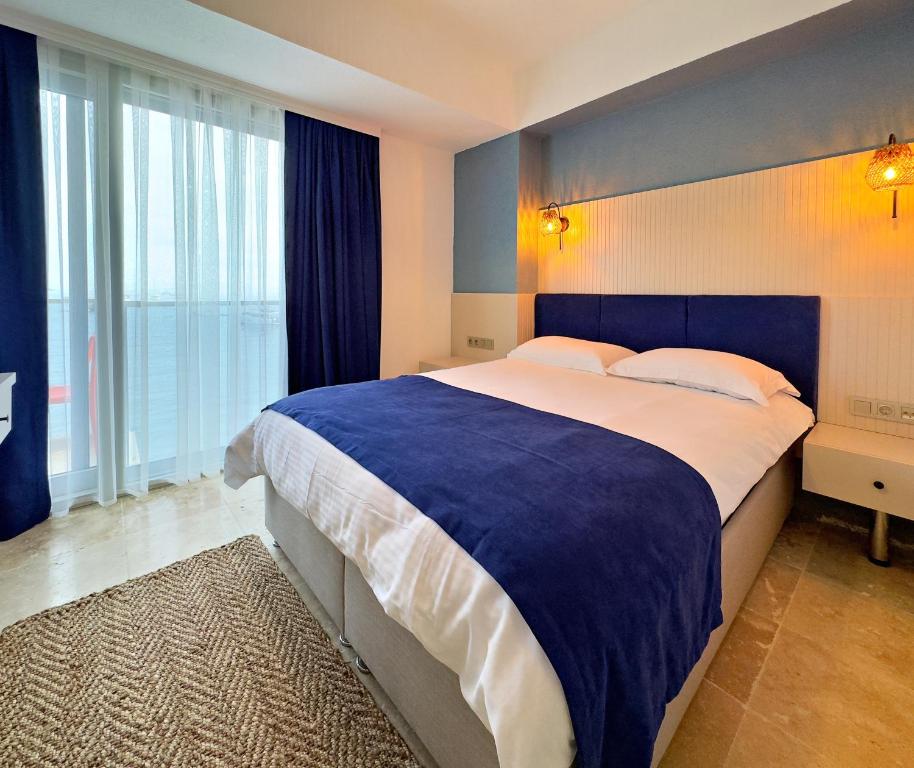 a bedroom with a large bed and a large window at Nese Pension in Bodrum City