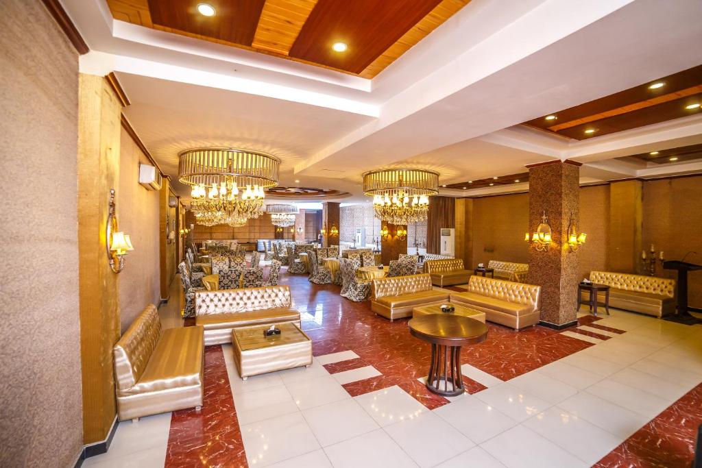 a lobby with couches and tables and chandeliers at Shelton's Rezidor Peshawar in Peshawar