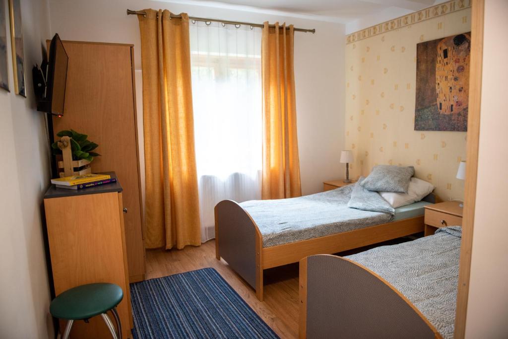 Habitación pequeña con 2 camas y ventana en Pensjonat Kaja, en Rymanów-Zdrój