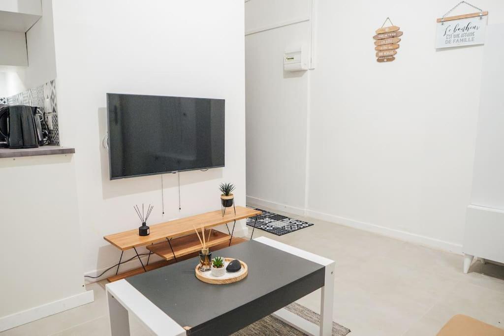 un soggiorno con tavolo e TV a schermo piatto di Appartement Cosy près de Paris et Disney a Neuilly-Plaisance