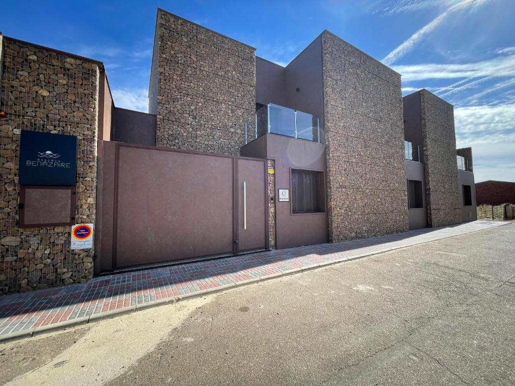 un gran edificio con una puerta en una calle en Reserva Benazaire, en Herrera del Duque