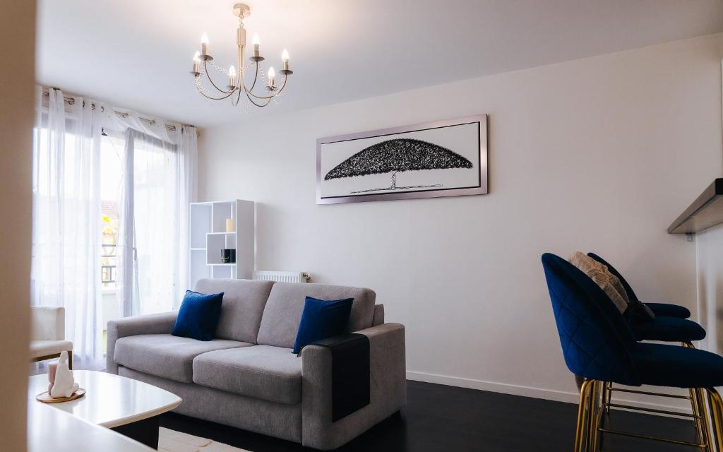 un salon avec un canapé et une chaise dans l'établissement Appartement luxueux, neuf & équipé à VERSAILLES, SAINT-CYR-L'ÉCOLE, à Saint-Cyr-lʼÉcole