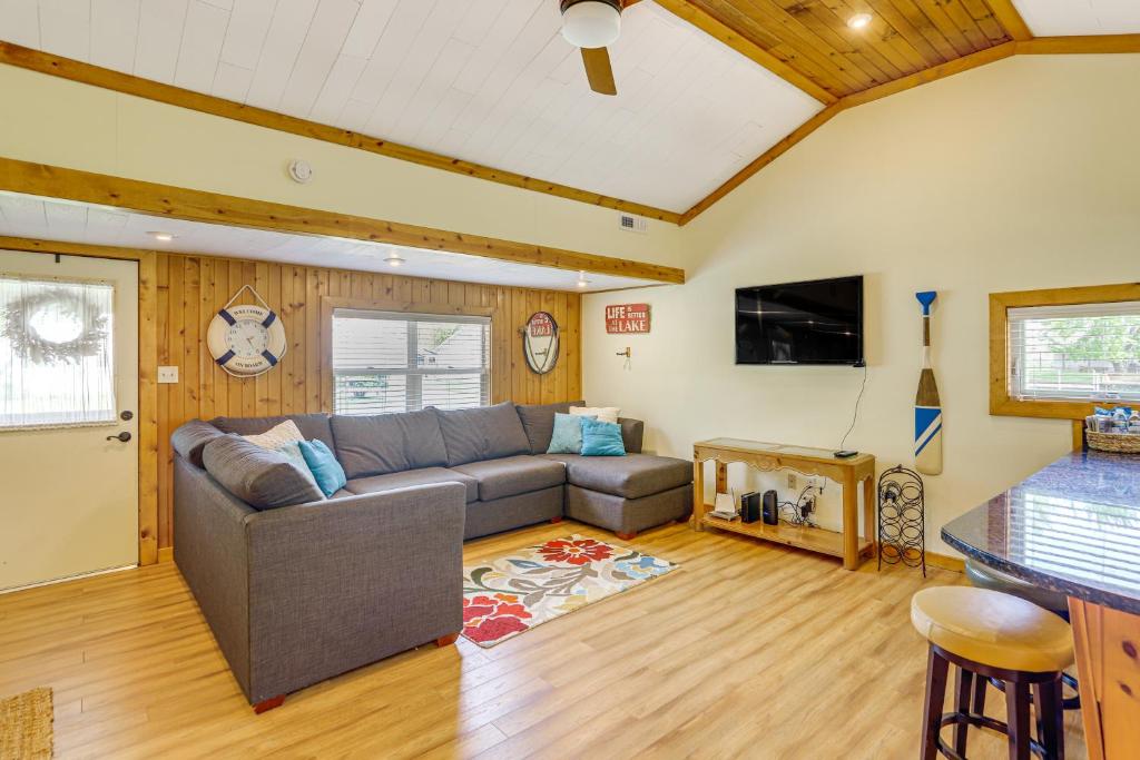 a living room with a couch and a flat screen tv at Waterfront Port Clinton Cottage with Fire Pit! in Port Clinton