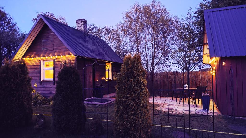 une petite maison avec des lumières sur son côté dans l'établissement Romantic, lovely sauna house in Estonian Countryside near the lake!, à Soe