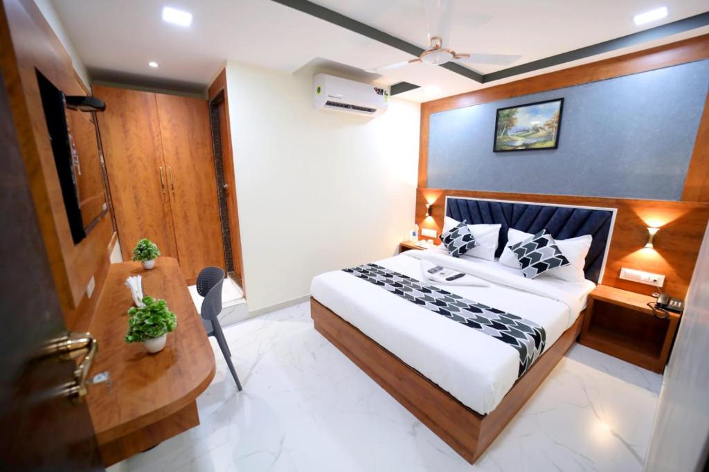 a hotel room with a bed and a desk and a bed at N.M. Hotel in Mumbai