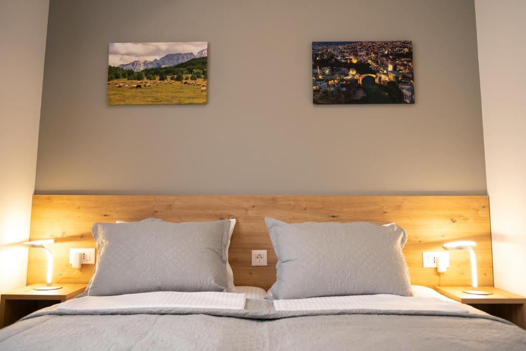 1 dormitorio con 1 cama con 3 cuadros en la pared en Imperial rooms en Mostar