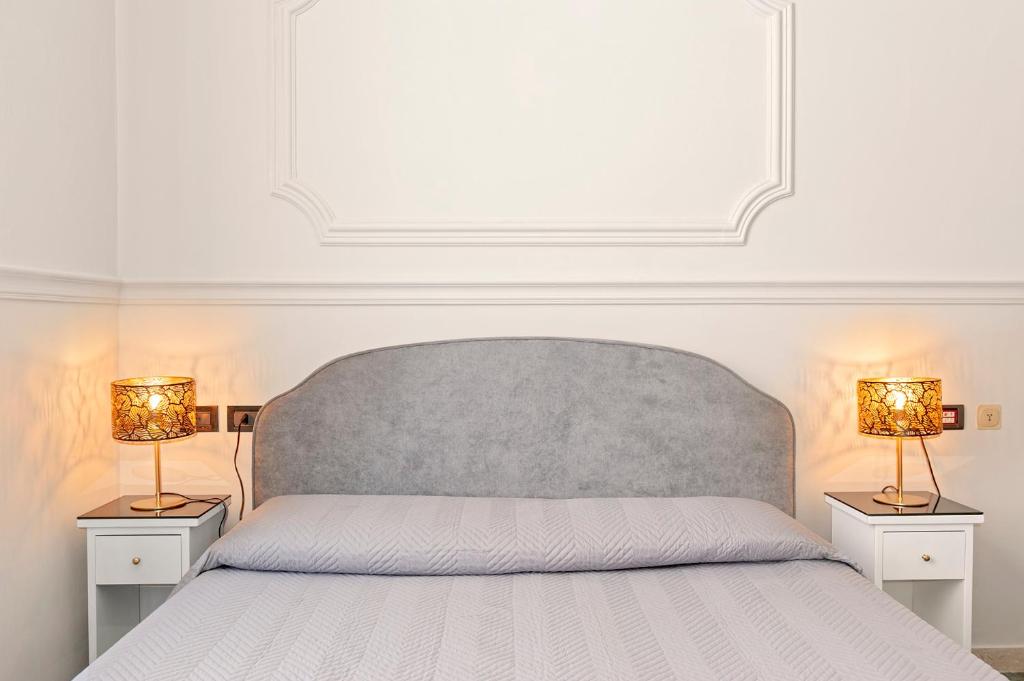 una camera da letto con un letto con due lampade su entrambi i lati di The Port Residence a Livorno