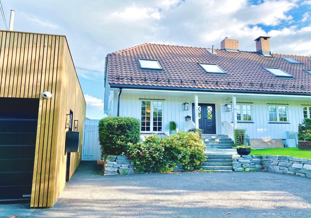 a white house with a brown roof at Apartment on idyllic Bygdøy with free parking in Oslo