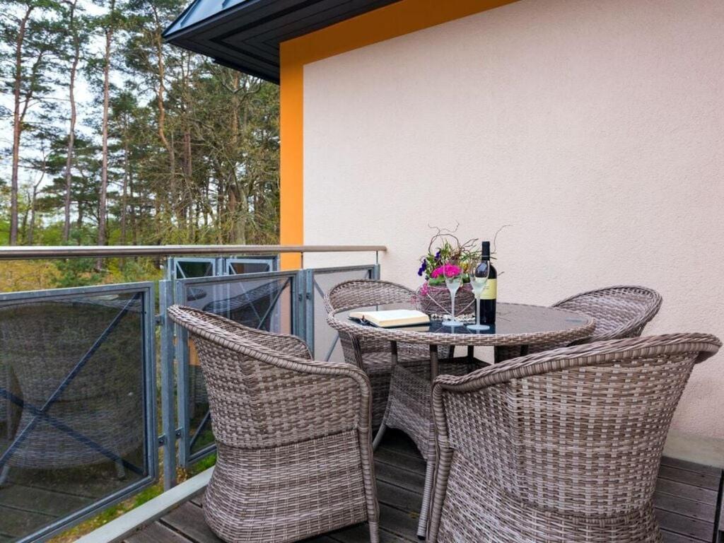 a table and chairs on a balcony with a bottle of wine at Time out Karlshagen in Karlshagen