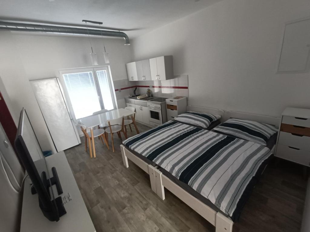 a small bedroom with a bed and a kitchen at MASNA APARTMENT LIBEREC in Liberec