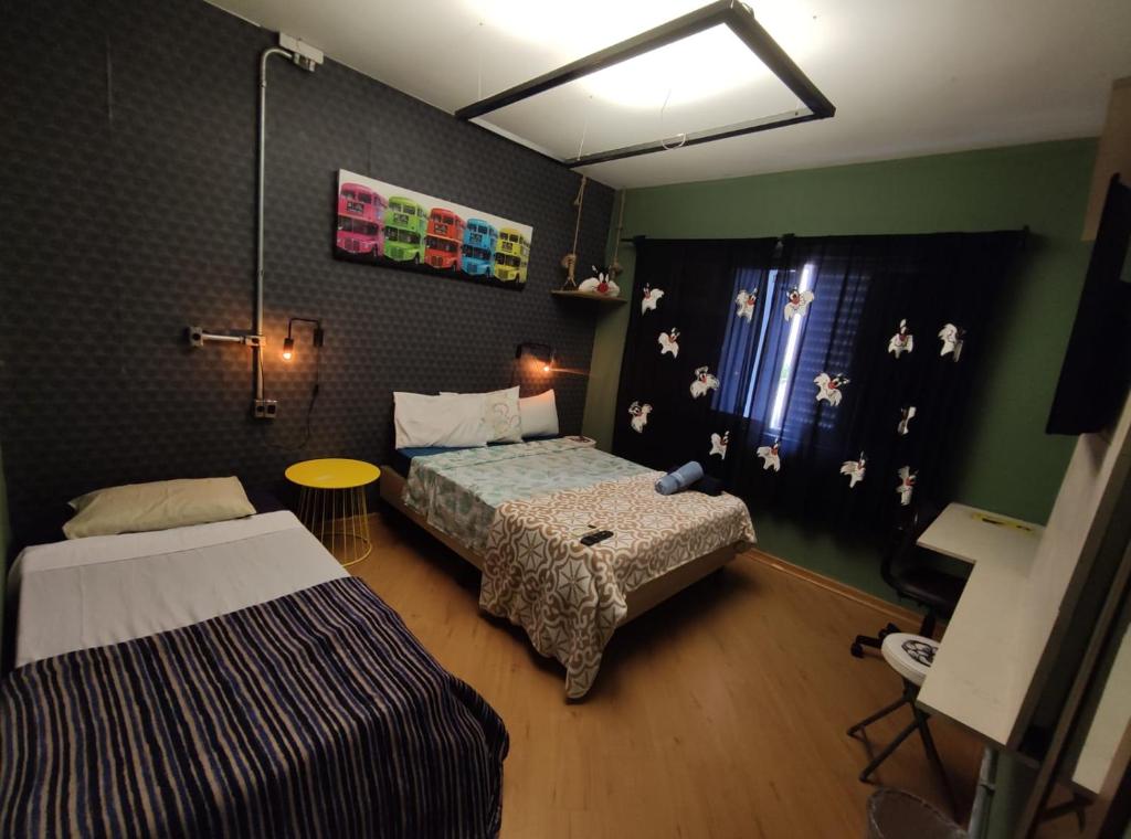 - une petite chambre avec 2 lits et une fenêtre dans l'établissement Pousada Casa dos Gattos - Próx ao Aeroporto Guarulhos, à Guarulhos