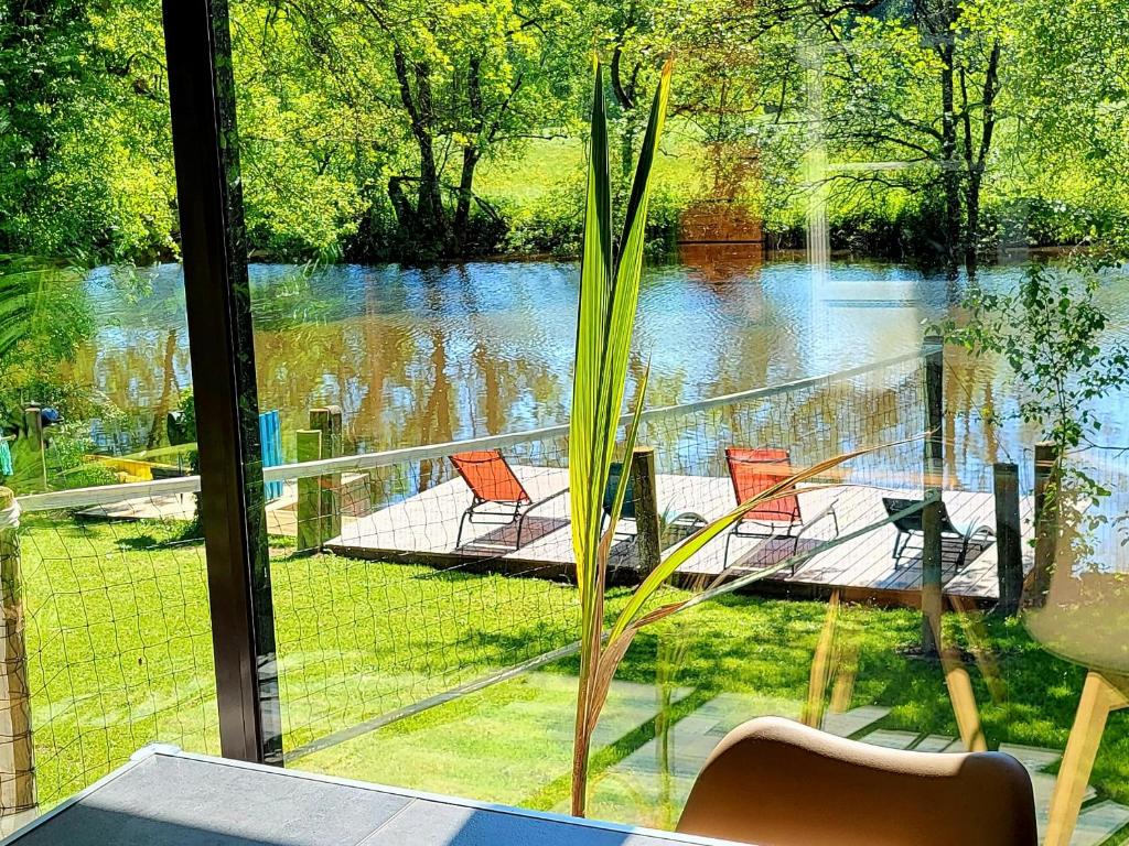 een kamer met uitzicht op een meer en stoelen bij Maison de vacances: chez Nirina in Mortagne-sur-Sèvre