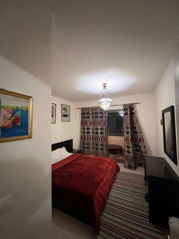 1 dormitorio con cama roja y ventana en Marasi Catania, en El Cairo