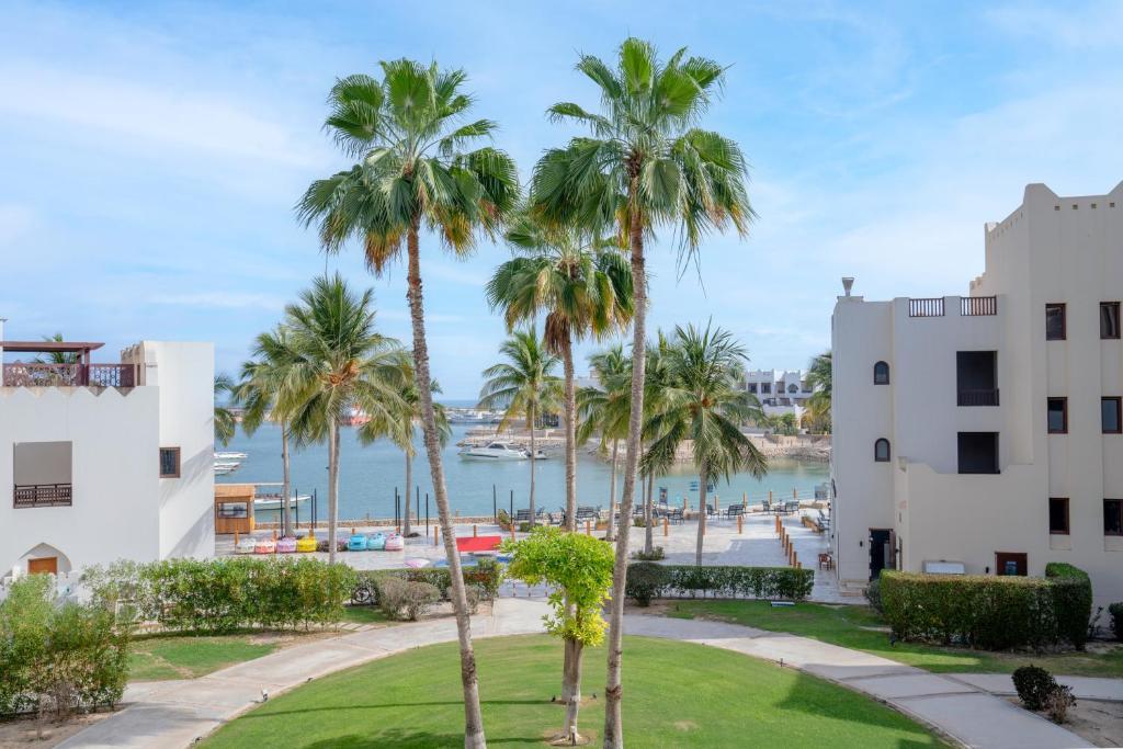 a view of the beach and palm trees in front of a building at Wateera Hawana Salalah in Salalah