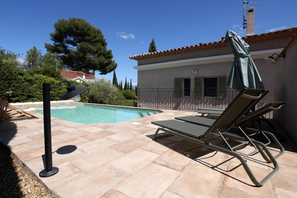 una silla junto a una piscina frente a una casa en Valdissol, en Sanary-sur-Mer