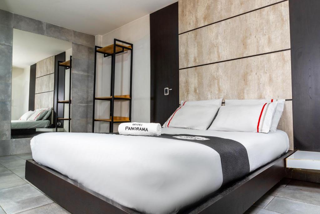 a bedroom with a large white bed in a room at Hotel Panorama Center in Medellín