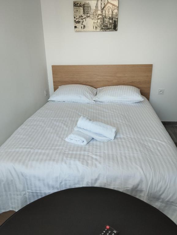 een bed met twee witte handdoeken erop bij Studio le pont de claix in Le Pont-de-Claix