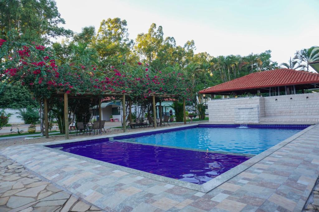 a swimming pool with purple water in a yard at Hotel Tropical Garden in Primavera do Leste