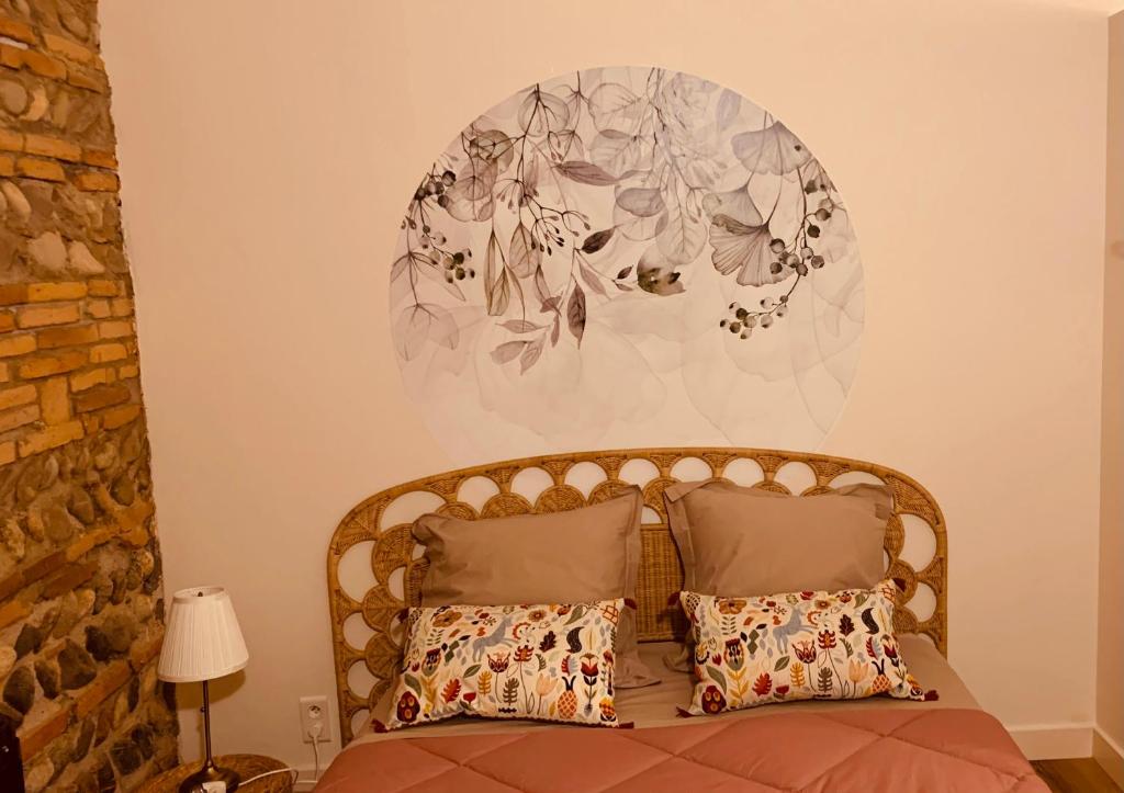 1 dormitorio con 1 cama con un mural de flores en la pared en La chambre de Lau en Noé