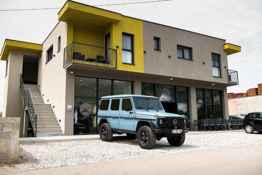 Niebieski jeep zaparkowany przed budynkiem w obiekcie Imperial rooms w mieście Mostar