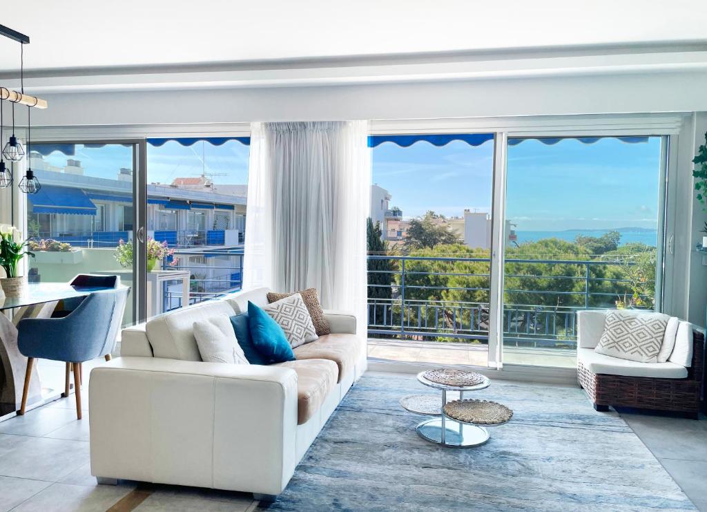 Elle comprend un salon doté d'un mobilier blanc et de grandes fenêtres. dans l'établissement Plage et hippodrome. Parking, à Cagnes-sur-Mer