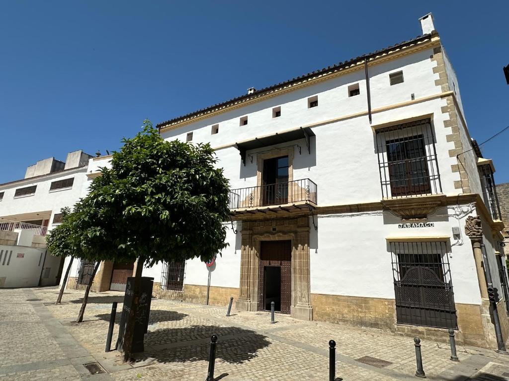 un edificio bianco con un albero di fronte di Casa Jaramago a Jerez de la Frontera