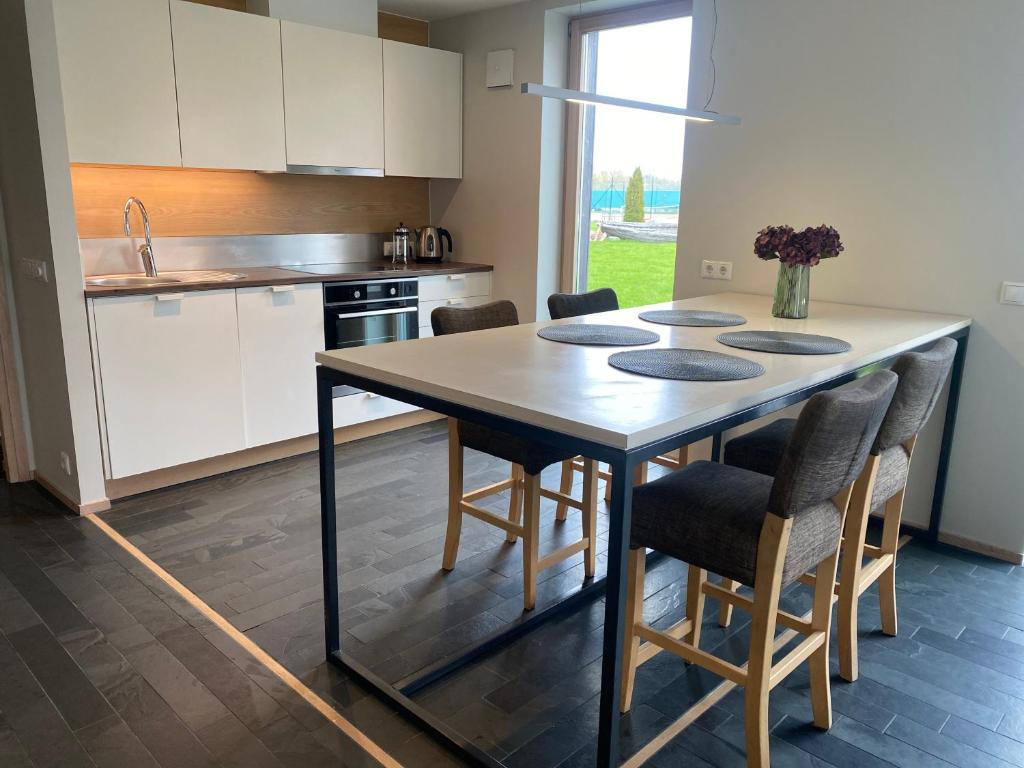Una cocina con una mesa con sillas y un fregadero. en YahtClub Apartment, en Kuressaare
