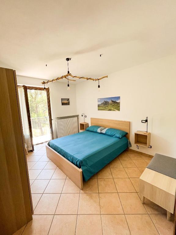 Roccaforte MondovìにあるCa Suvranのベッドルーム1室(大型ベッド1台、青い掛け布団付)