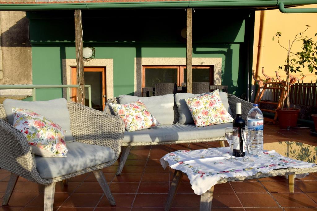 un patio con sofás y una mesa con una botella de agua en Green House, en Oporto