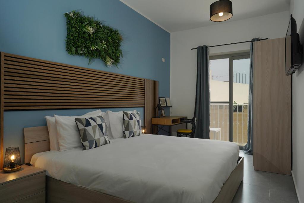 a bedroom with a large white bed and a window at Modern 5-Bedroom Apartment Central Malta in Mosta