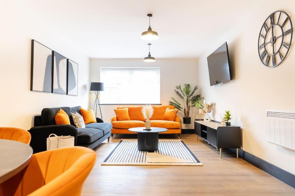 a living room with an orange couch and a table at The Berriman Collection Stylish 2 Bedroom Apartment in Cardiff