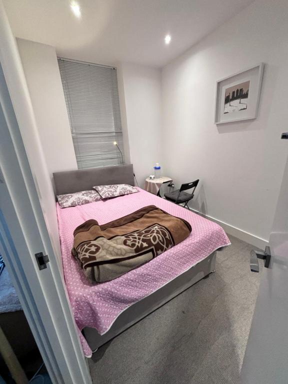 1 dormitorio con 1 cama con manta rosa en Bath Road Slough Home Stay en Slough
