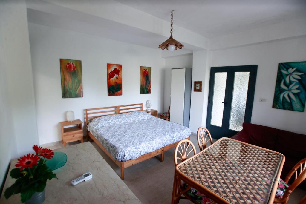 1 dormitorio con 1 cama, mesa y sillas en Friends sea house, en Messina
