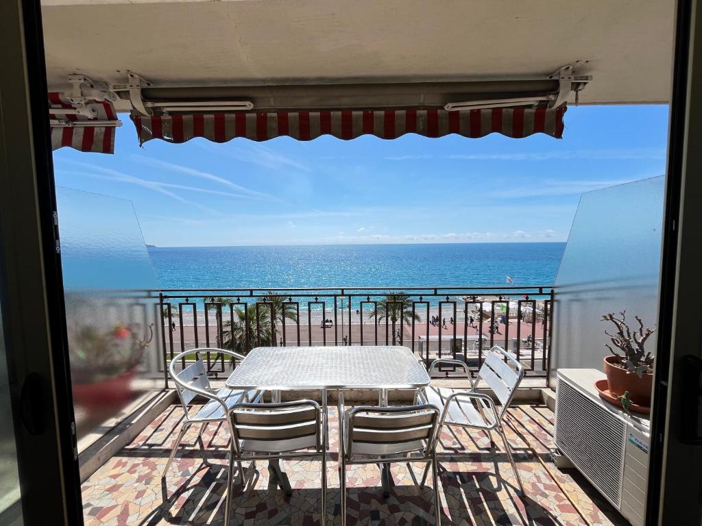 une table et des chaises sur un balcon avec l'océan dans l'établissement Sea View and Promenade, à Nice
