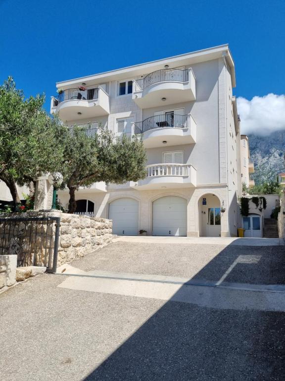 a large white building with two garage doors at Apartments Tomaš in Makarska
