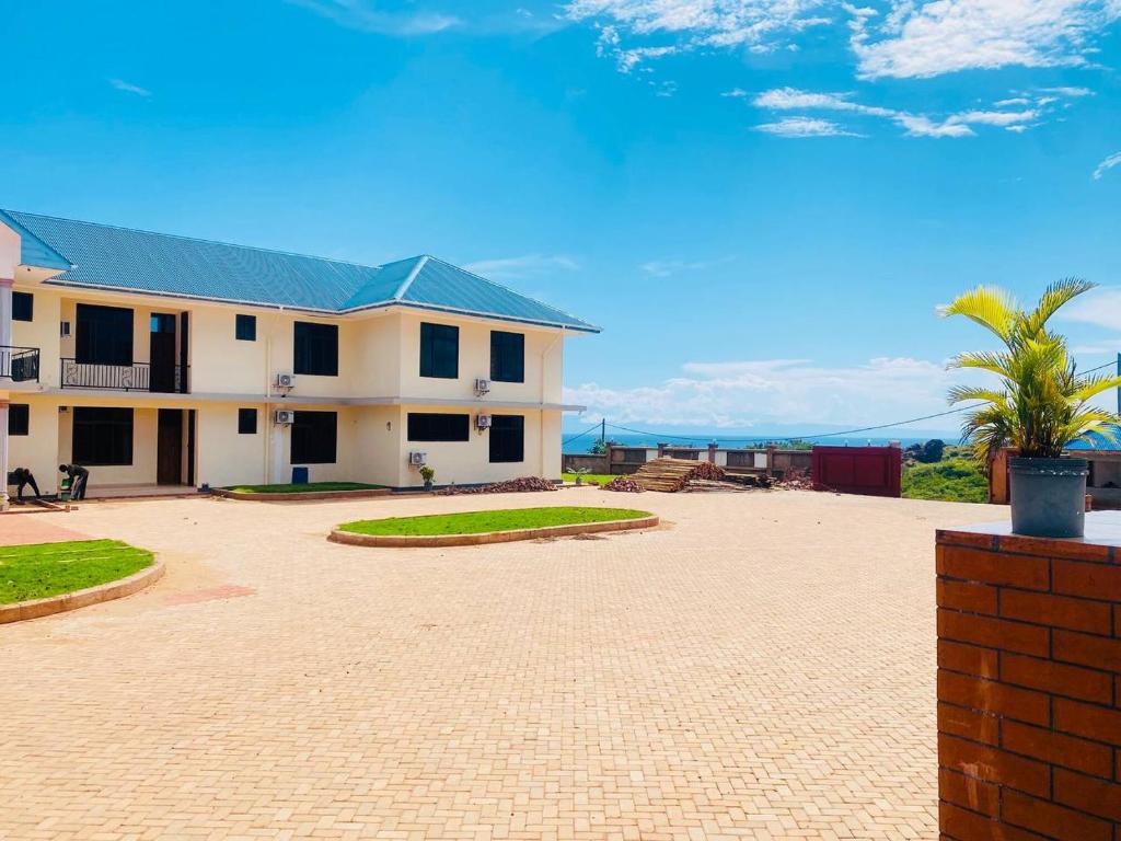 una casa bianca con tetto verde e cortile di St Paul's Hostels Buhabugali Kigoma a Kigoma