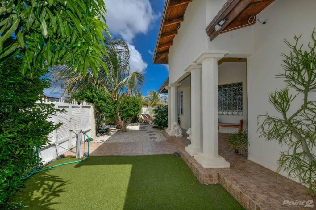 a house with a yard of green grass at Cas Amigos Villa in Palm-Eagle Beach