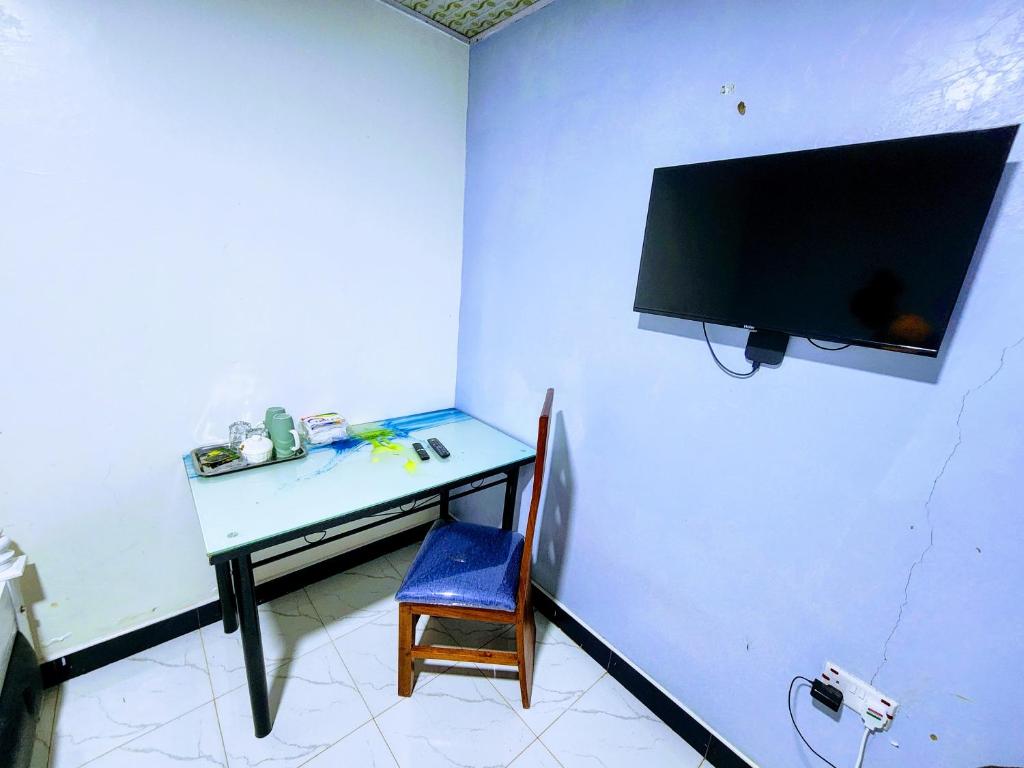 una camera con scrivania e TV appesa a un muro di Swift Haven Stays a Chuka