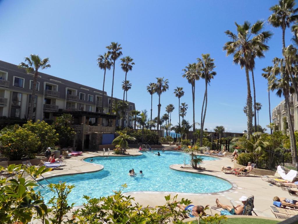 uma piscina num resort com palmeiras em Oceanview Retreat - Steps to the Beach and 2 Pools em Oceanside